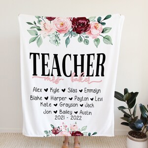 May include: White fleece blanket with a floral design and the text "TEACHER mrs. baker" in black. Below the text are the names of students, "Alex, Kyle, Silas, Emmalyn, Blake, Harper, Payton, Levi, Kate, Grayson, Jack, Jon, Bailey, Austin" and the dates "2021 - 2022".