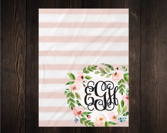 May include: A white and pink striped background with a floral wreath and monogram. The wreath features pink roses and green leaves. The monogram is in a black, elegant script. The overall design is soft and feminine.