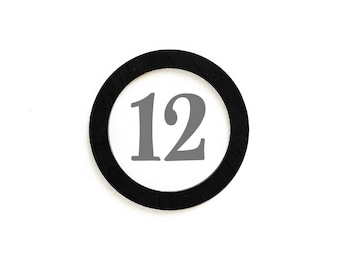 May include: A circular black object with the number 12 in gray inside a white circle. The number is centered within the circle. The background is plain white.