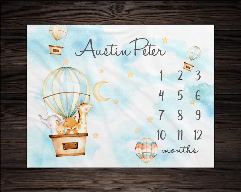 May include: A blue and white hot air balloon with a giraffe, fox, and elephant inside. The balloon is surrounded by clouds and stars. The text "Austin Peter" is written above the balloon. Below the balloon are numbers 1 through 12, representing months. The text "months" is written below the numbers.