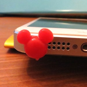 May include: A red plastic Mickey Mouse head phone jack cover.