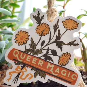 Puede incluir: Una pegatina con un ramo de flores amarillas y una pancarta que dice "Queer Magic".