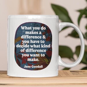May include: White ceramic mug with a quote by Jane Goodall, "What you do makes a difference & you have to decide what kind of difference you want to make." The mug sits on a stack of books next to a globe.