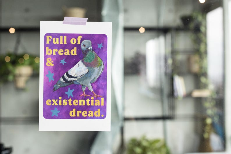 K&ouml;nnte beinhalten: Ein rechteckiger Druck mit einem Taubenmotiv vor einem violetten Hintergrund mit blauen Sternen. Der Text lautet Full of bread & existential dread. Der Druck ist mit einem hellvioletten Klebestreifen am oberen Rand befestigt.