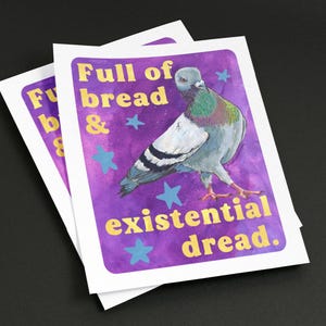 K&ouml;nnte beinhalten: Ein rechteckiger Druck mit einer grauen Taube mit schillernden gr&uuml;nen und violetten Halsfedern vor einem leuchtend violetten Aquarellhintergrund. Der Text "Full of bread & existential dread." ist in Gelb gedruckt, erg&auml;nzt durch hellblaue Sterne.