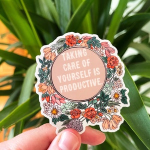 May include: A sticker with a floral wreath design and the text "Taking care of yourself is productive."