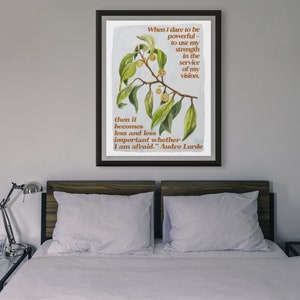 K&ouml;nnte beinhalten: Ein gerahmter Druck mit einer botanischen Illustration eines Zweigs mit gr&uuml;nen Bl&auml;ttern und gelben Beeren. Der Druck zeigt ein Zitat von Audre Lorde: "Wenn ich es wage, m&auml;chtig zu sein - meine Kraft im Dienste meiner Vision einzusetzen, dann wird es immer weniger wichtig, ob ich Angst habe."