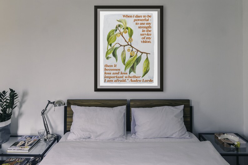 K&ouml;nnte beinhalten: Ein gerahmter Druck mit einer botanischen Illustration eines Zweigs mit gr&uuml;nen Bl&auml;ttern und gelben Beeren. Der Druck zeigt ein Zitat von Audre Lorde: "Wenn ich es wage, m&auml;chtig zu sein - meine Kraft im Dienste meiner Vision einzusetzen, dann wird es immer weniger wichtig, ob ich Angst habe."