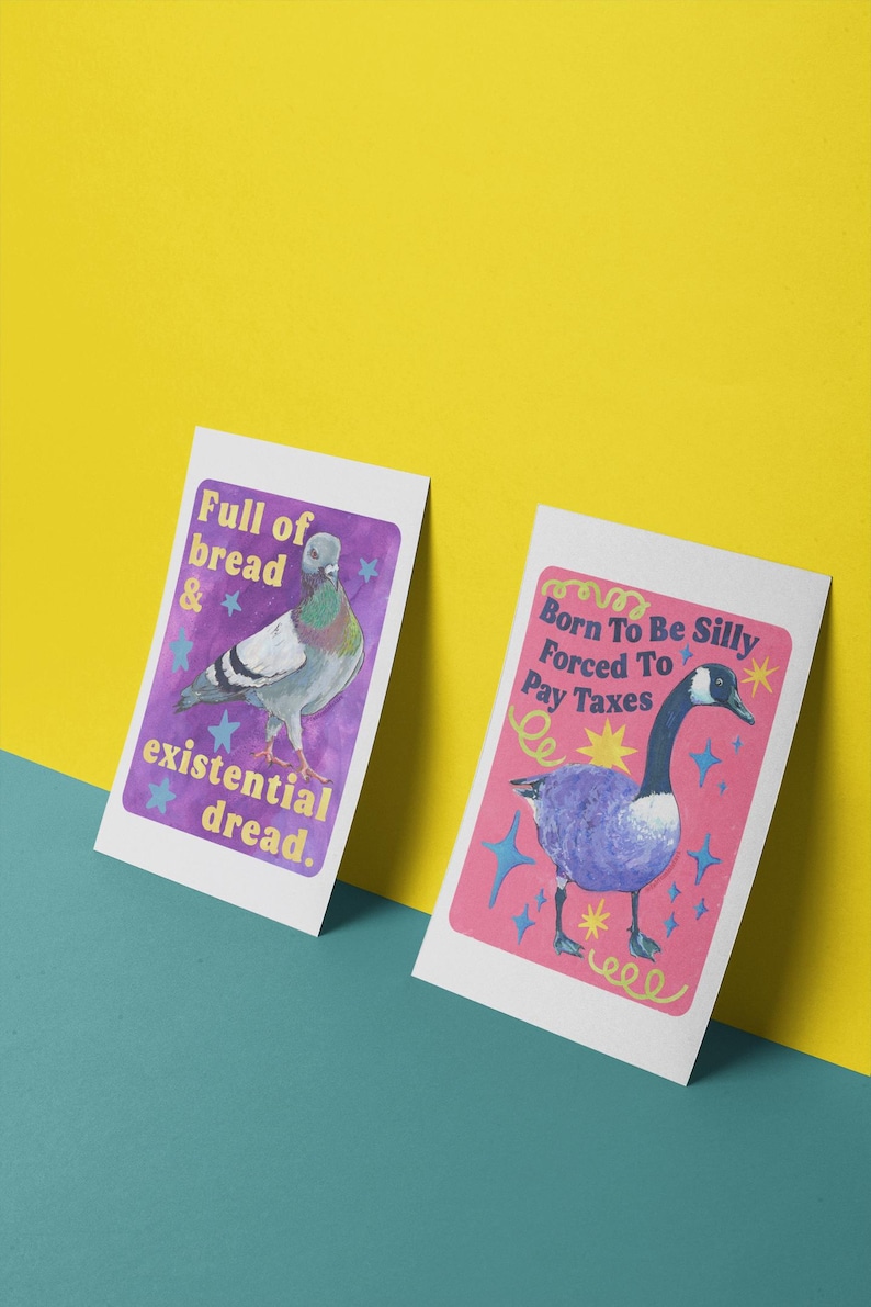 K&ouml;nnte beinhalten: Zwei rechteckige Kunstdrucke. Der linke Druck zeigt eine Taube auf violettem Hintergrund mit dem Text Full of bread & existential dread. Der rechte Druck zeigt eine Gans auf rosa Hintergrund mit dem Text Born To Be Silly Forced To Pay Taxes.