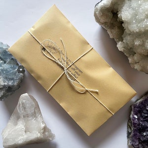 May include: A brown paper envelope tied with twine, with the text "Follow me on Instagram and check off your Fab Finds list! @stabler.krist" printed on the front.