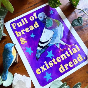 K&ouml;nnte beinhalten: Ein rechteckiger Kunstdruck mit einer Taube vor einem leuchtend violetten Hintergrund mit hellblauen Sternen. Der Text lautet Full of bread & existential dread. Die Taube hat graue, wei&szlig;e und schillernd gr&uuml;ne Federn sowie rosa F&uuml;&szlig;e.