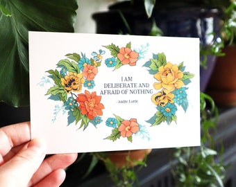 May include: A white card with a floral wreath border and a quote by Audre Lorde: "I am deliberate and afraid of nothing."
