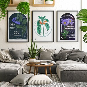 May include: Three framed art prints with floral illustrations and inspirational quotes. The prints are hanging on a white wall above a gray sectional sofa. The quotes are "Rarely, if ever, are any of us healed in isolation. Healing is an act of communion. bell hooks."  "The practice of love is the most powerful antidote to the violence of our times. bell hooks." and "If we want a Beloved Community, We Must Stand For Justice."