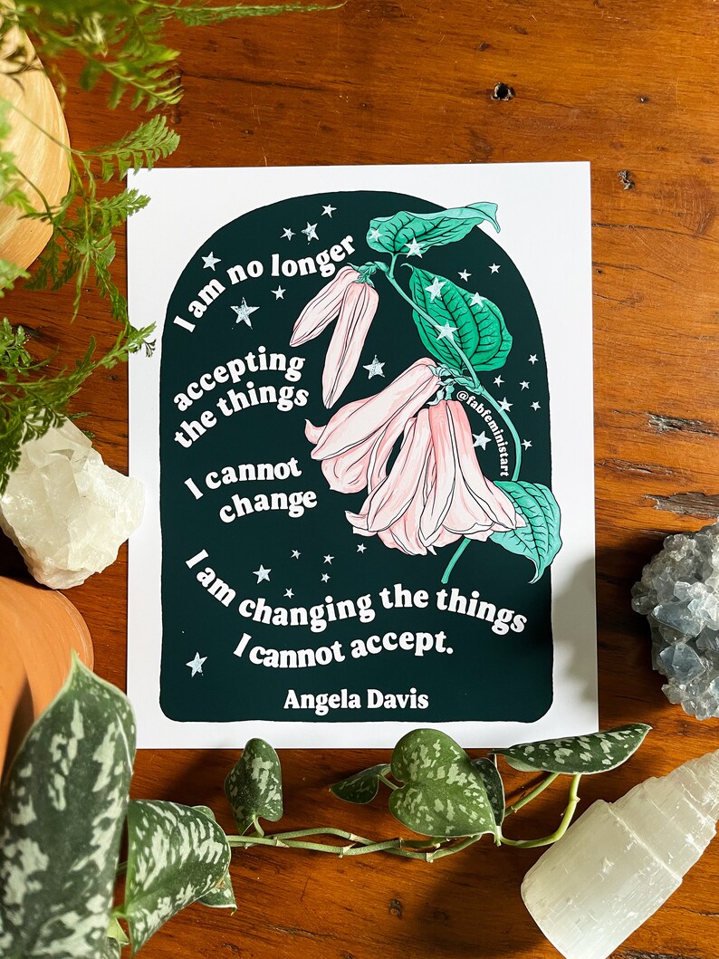 May include: A black and green print with a quote by Angela Davis: "I am no longer accepting the things I cannot change. I am changing the things I cannot accept."