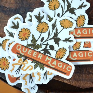 Puede incluir: Un conjunto de pegatinas con un ramo de flores amarillas con hojas verdes y una pancarta que dice "Queer Magic". Las pegatinas tienen un estilo vintage con detalles en naranja y marr&oacute;n.