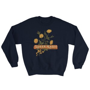 Könnte beinhalten: Navyblauer Sweatshirt mit einem Aufdruck von gelben Blumen und dem Text "Queer Magic" in Orange und Weiß.