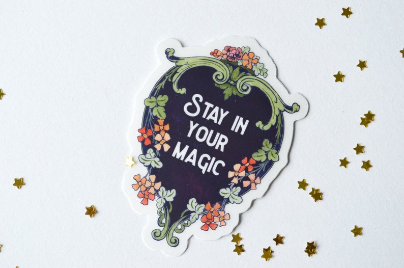 May include: A sticker with a floral design and the text "Stay in your magic" in a white font on a dark blue background.