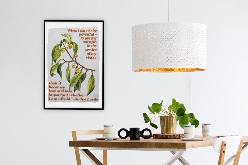 K&ouml;nnte beinhalten: Ein gerahmter Druck mit einer Aquarell-Illustration eines belaubten Zweigs mit kleinen gelben Beeren. Der Druck zeigt ein Zitat von Audre Lorde: "Wenn ich es wage, m&auml;chtig zu sein - meine Kraft im Dienste meiner Vision einzusetzen. Dann wird es immer weniger wichtig, ob ich Angst habe."
