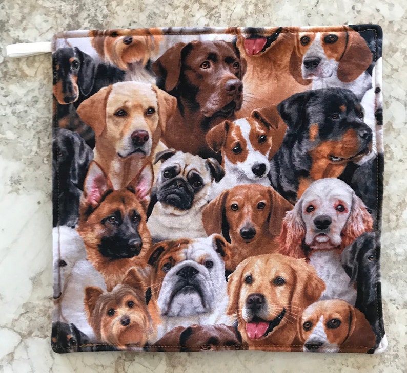 May include: A colorful fabric pot holder with a pattern of various dog breeds, including a Labrador Retriever, a German Shepherd, a Pug, and a Bulldog.