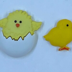 May include: Two yellow chick decorations. One chick is emerging from a white eggshell, and the other is a standalone chick. Both have black eyes and orange beaks, perfect for Easter or spring crafts.