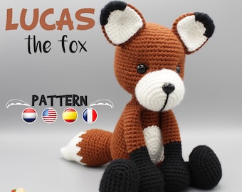May include: Crocheted fox amigurumi toy named Lucas, sitting with its legs crossed. The fox is brown with white accents and black ears and feet. The toy is made with yarn and has a cute, friendly expression.