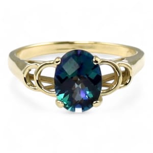 May include: A gold ring with an oval-shaped blue gemstone set in a delicate, twisted band.