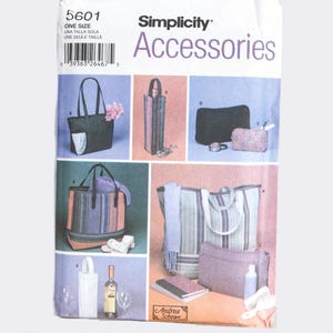 May include: Simplicity Accessories sewing pattern featuring various bag designs. The pattern includes tote bags, a wine bottle carrier, and cosmetic bags. The bags are shown in different colors and patterns, with the text "Simplicity Accessories" at the top.