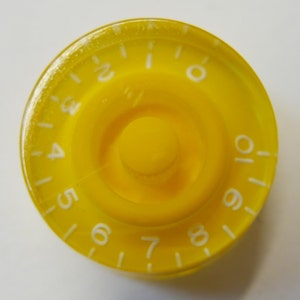 Pode incluir: Botão de guitarra amarelo com números brancos de 1 a 10.