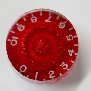 May include: Red knob with white numbers 1 through 10 around the edge. The knob is covered in red glitter.