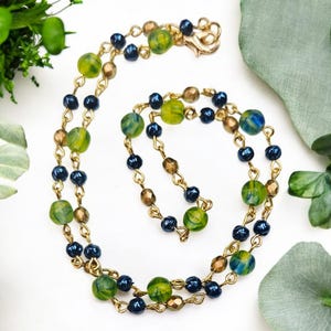 Bring color to your day with this Green, Gold & Blue Simple Everyday Necklace, designed to be timeless yet unique.
Beads used in design:
6mm matte green-blue milky swirl Czech glass beads (the centerpiece of this design) alternating with 4mm Vintage Czech Blue Baroque Pearl beads for soft luster and Gold faceted accent beads for a hint of sparkle
• Chain: Gold-plated chain links connecting each bead
• Clasp: Gold lobster clasp for a secure, polished finish
An original design, only found here.
