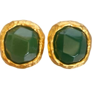 May include: A pair of gold-toned earrings with green gemstone accents. The earrings have a textured, hammered finish.