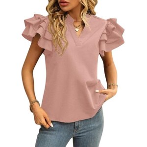 May include: A dusty rose-colored blouse with ruffled cap sleeves and a V-neckline. The top has a relaxed fit and a subtle pocket detail. The model is wearing blue jeans. The blouse is a stylish addition to any wardrobe.