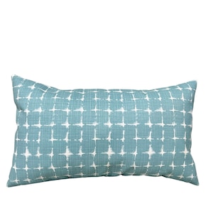 May include: A teal blue rectangular pillow with a white geometric pattern.