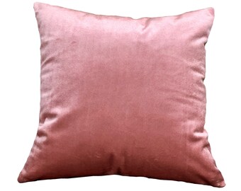 May include: A soft, blush pink velvet pillow with a square shape.