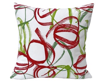 May include: White throw pillow with a red and green abstract design. The design features swirling lines and circles.