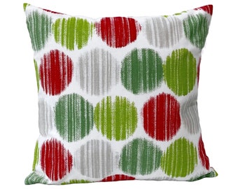 May include: A white throw pillow with a red, green, and gray polka dot pattern. The dots are made of brushstrokes.