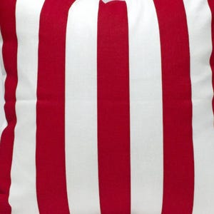 May include: Red and white striped throw pillow. The pillow is made of a soft, comfortable fabric and has a classic striped pattern.