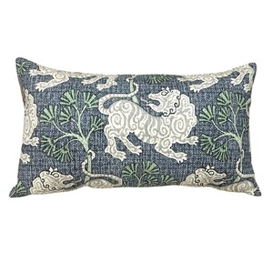 May include: A blue rectangular pillow with a white and green pattern of stylized lions and trees.