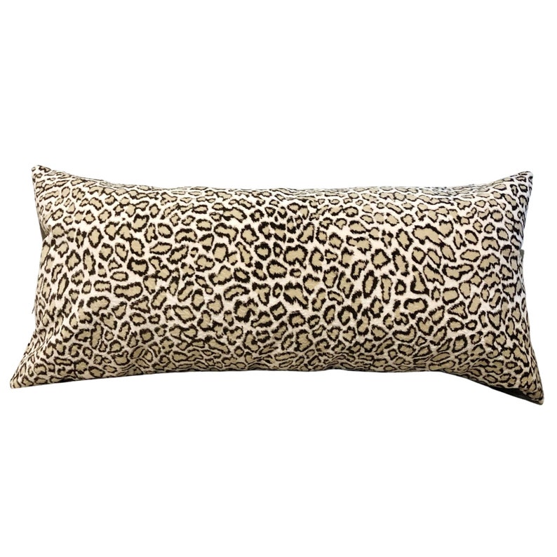 May include: A long, rectangular cushion with a brown and beige leopard print pattern.