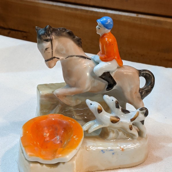 Figura vintage con cenicero, herradura naranja y un cazador guapo (década de 1930)