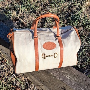Bolso de lona vintage con ribete de cuero color canela y detalles dorados, E.M. Lastrai Saddlery, 2001