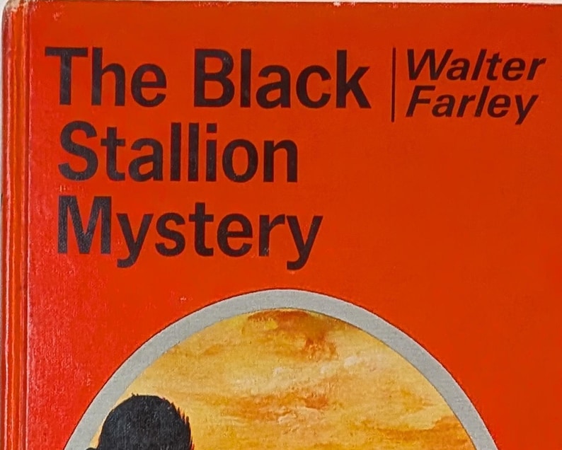 a book cover that is red with a black horse and rider on the front. The title is THE BLACK STALLION MYSTERY BY WALTER FARLEY