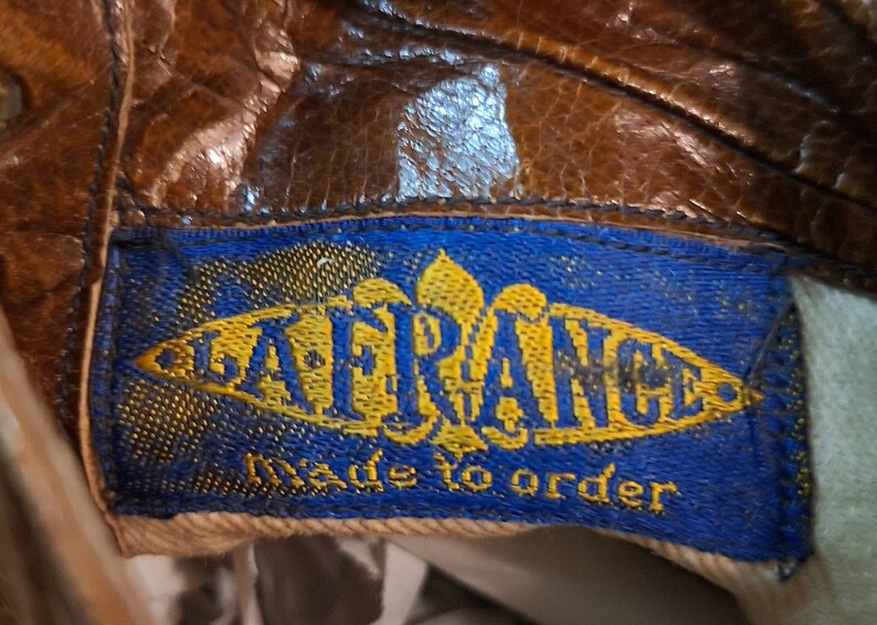 A label inside a pair of ladies brown leather Victorian lace up boots. The label is blue and gold and reads LA FRANCE Made to Order