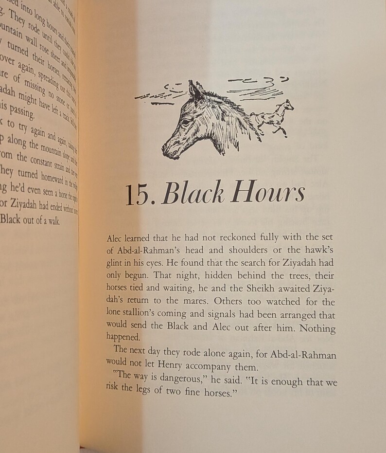 An open book page with text and a black and white illustration of a horse's head and a running horse. The text reads "15. Black Hours". The page has a cream-colored background.