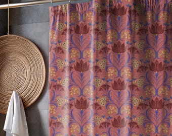 May include: A floral patterned shower curtain in shades of pink, burgundy, purple, and yellow. The curtain hangs in front of a white bathtub. The bathroom has a wooden floor, a small wooden stool, and a woven basket.