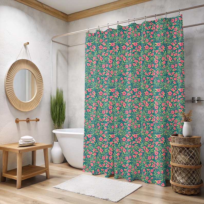 May include: Teal shower curtain with a repeating floral pattern of pink flowers and green leaves. The bathroom features a wooden side table, a round mirror, and a white bathtub.