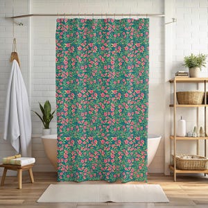 May include: A teal shower curtain with a repeating floral pattern. The design features pink flowers and green leaves. The curtain is hanging in a bathroom setting, adding a touch of nature to the space.