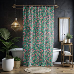 May include: A teal shower curtain with a repeating floral pattern of pink flowers and green leaves. The curtain hangs in front of a white bathtub, adding a pop of color to the bathroom decor.