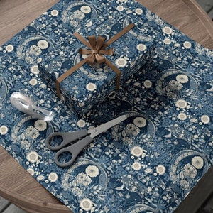 May include: A blue and white floral patterned gift wrap with a brown ribbon and bow on top of a wrapped gift box.