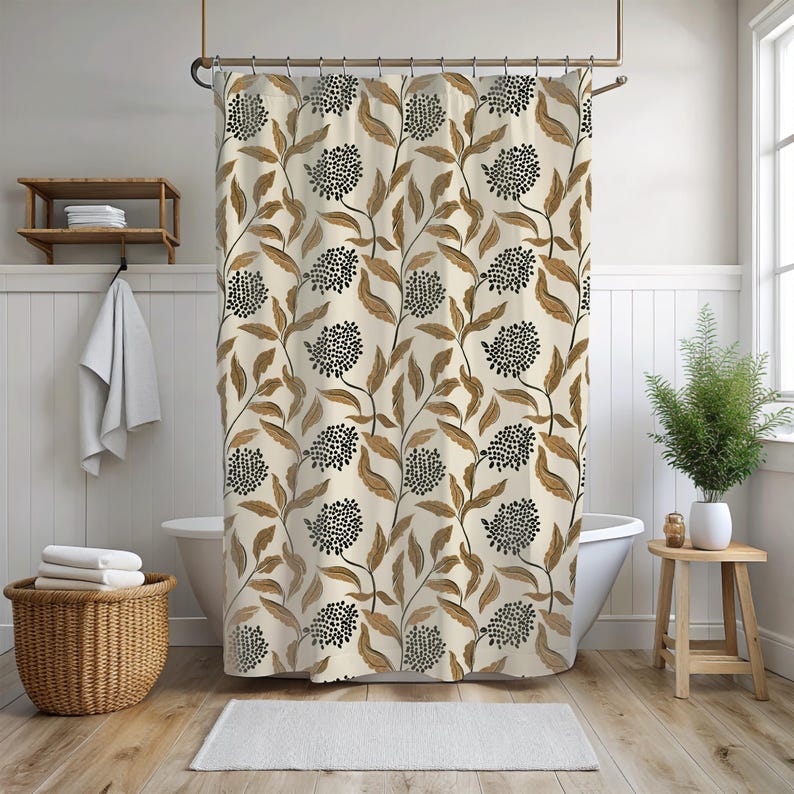 May include: A beige shower curtain with a repeating pattern of black dotted flower clusters and brown leaves and stems. The curtain hangs in front of a white bathtub in a bathroom with a wooden floor and a small wooden side table.